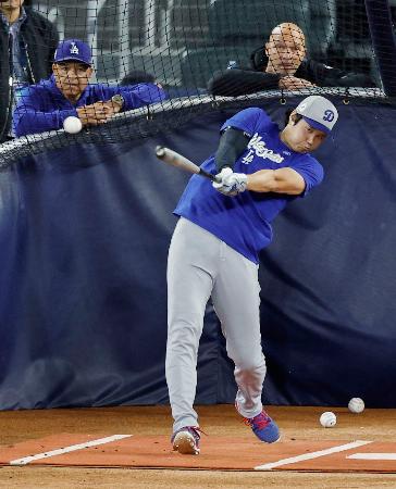 グラウンドで打撃練習するドジャース・大谷。左はロバーツ監督＝トロント（共同）