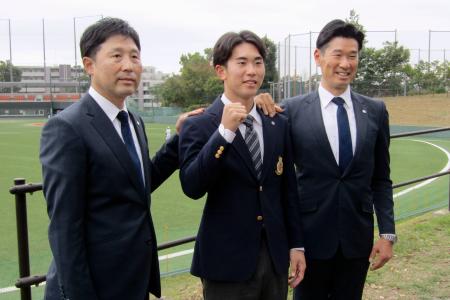 西武からドラフト１位で指名され、写真に納まる明大の小島（中央）。右は西武の広池浩司球団本部長＝３１日、東京都府中市