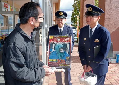 コンビニ店長強盗殺人事件の現場近くで、商業施設の利用客に情報提供を呼びかける石川県警大聖寺署の小坂裕署長（右）ら＝１日午前、石川県加賀市