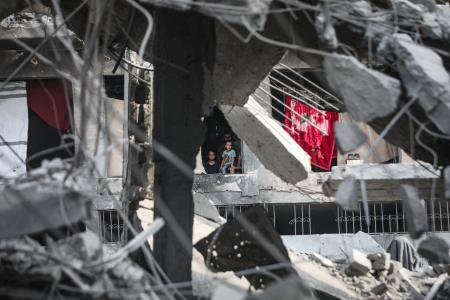 イスラエル軍による停戦後の攻撃でがれきと化した建物の中で暮らすパレスチナ人家族＝３日、ガザ北部ガザ市（ゲッティ＝共同）