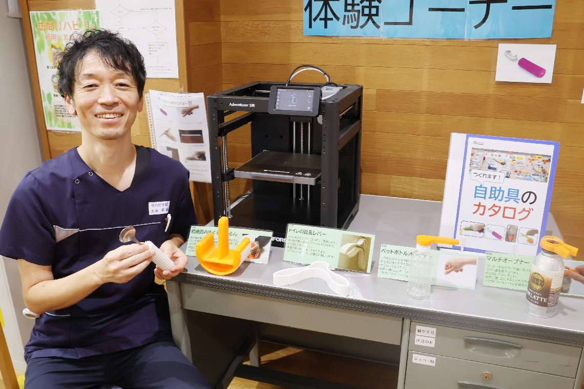 ３Ｄプリンターで自助具を作る作業療法士の平岡淳也さん＝別府市照波園町の黒木記念病院