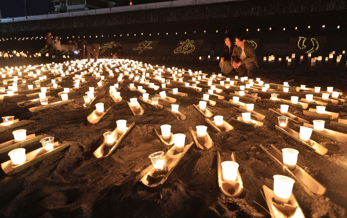 幻想的な光で河川敷を照らす「花月あかり」＝７日夜、日田市の花月川河川敷