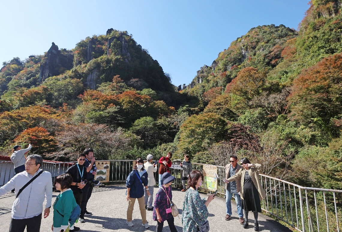 色づき始めた紅葉を写真に収める観光客ら＝７日、中津市耶馬渓町深耶馬の一目八景