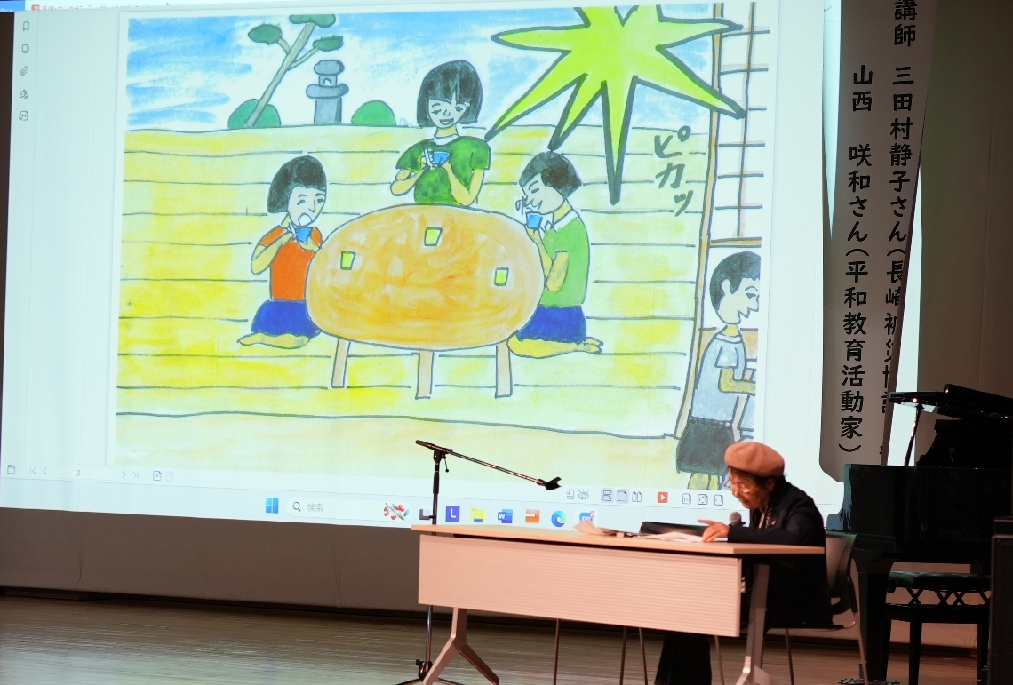 自作のイラストを使って被爆当時の状況を話す三田村静子さん