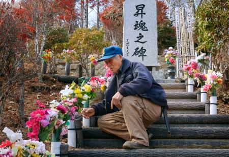 造花を供える登山道の管理人・黒沢完一さん＝１４日午後、群馬県上野村