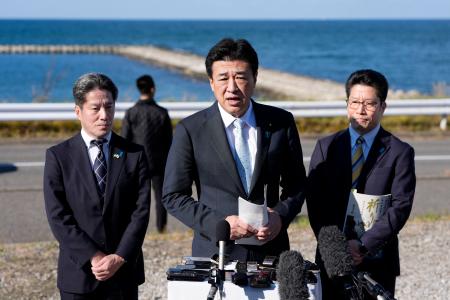 横田めぐみさんが北朝鮮工作員に拉致されたとみられる現場周辺を視察し、記者団の取材に応じる木原官房長官。めぐみさんの弟拓也さん（右）と哲也さん（左）も同行した＝１５日午後、新潟市