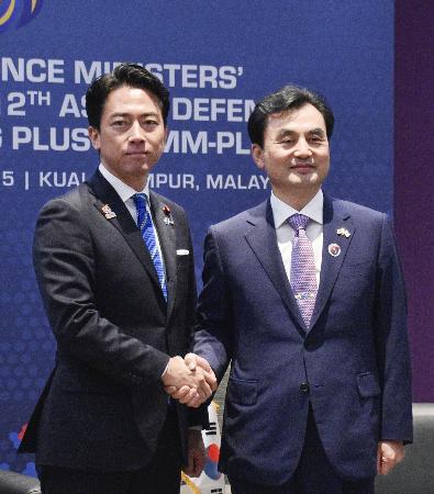 会談で握手する小泉防衛相（左）と韓国の安圭伯国防相＝１日、クアラルンプール（共同）