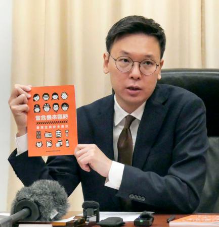 ハンドブックを手に取材に応じる林飛帆氏＝１２日、台北市（共同）