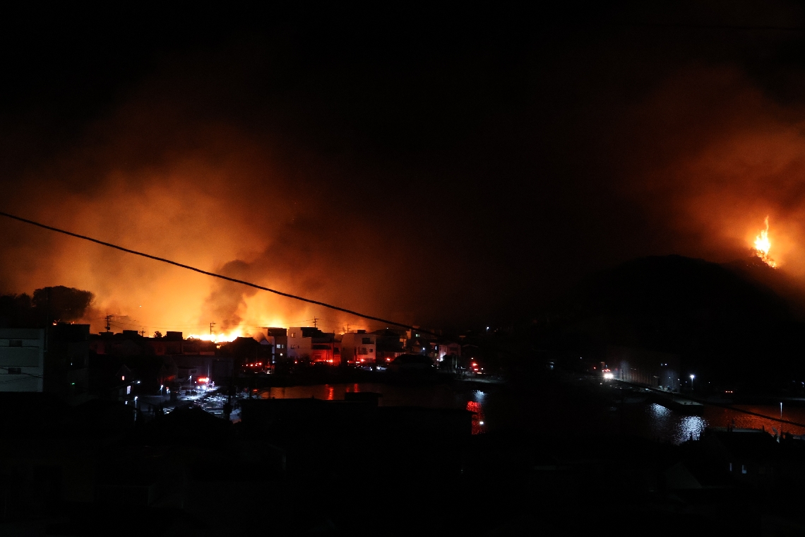 集落から山林（右）にも飛び火＝１８日午後８時半