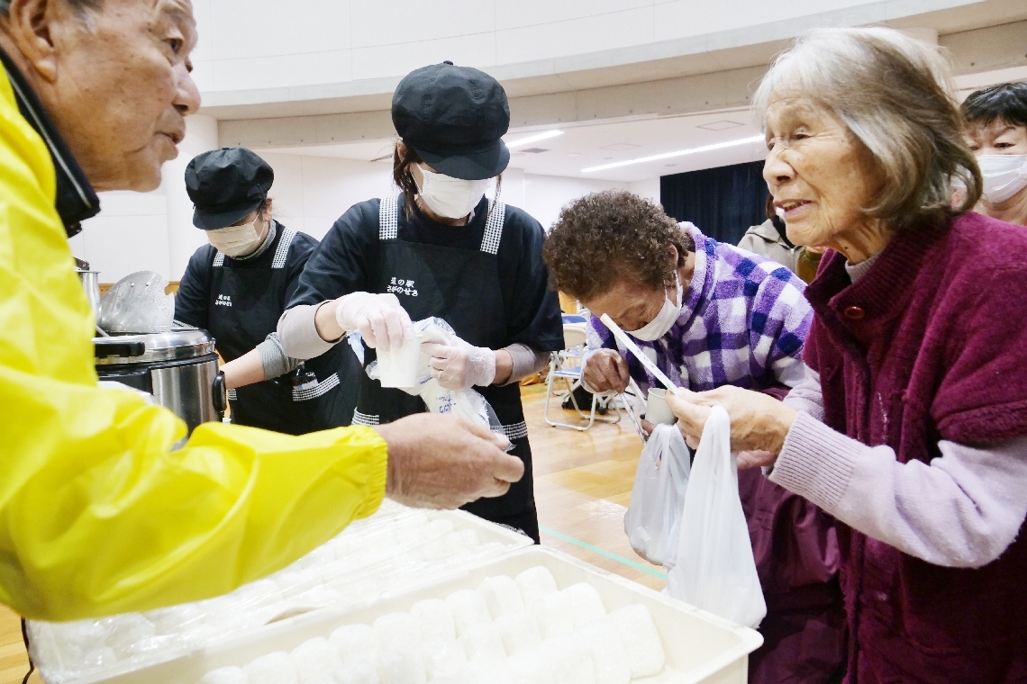 おにぎりやクロメ汁を受け取る避難者＝１９日午前８時５９分、大分市佐賀関