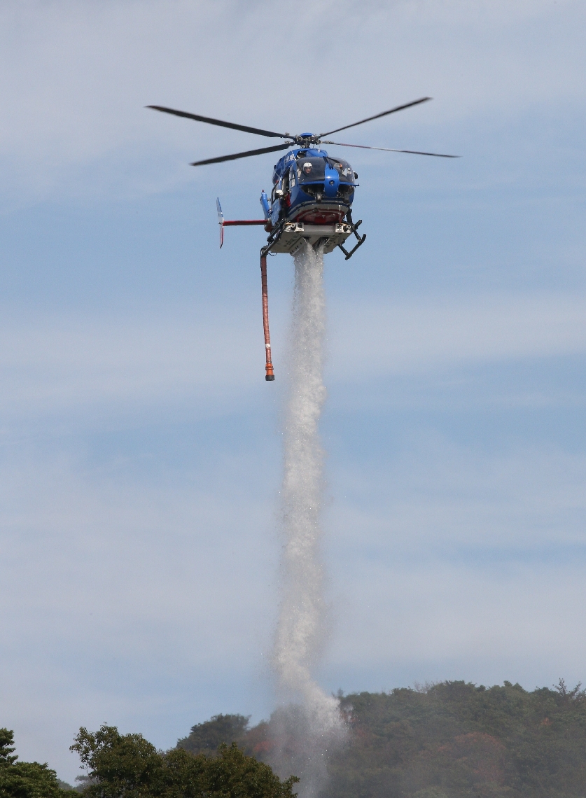 消火活動をする県防災ヘリコプター「とよかぜ」＝１９日午後２時４０分