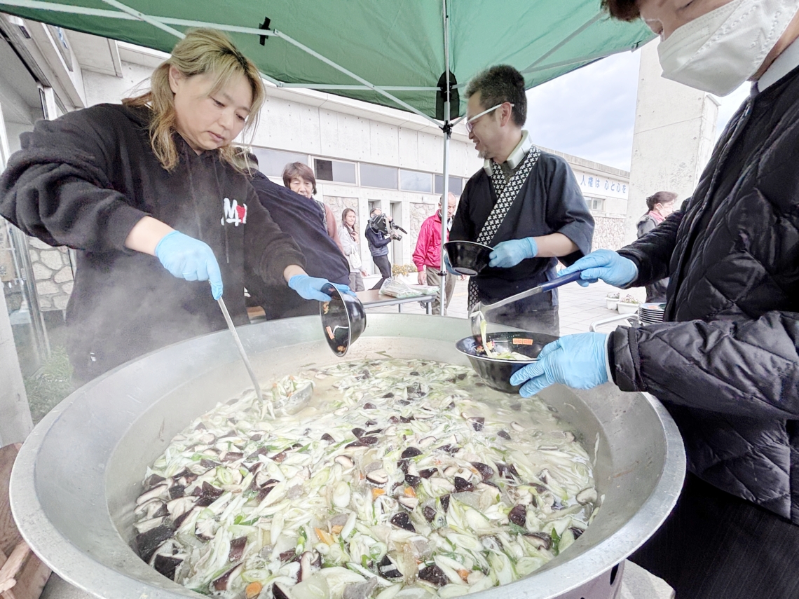 被災者に豚汁をふるまうボランティア＝１９日午後１時１分