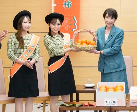 奈良県特産の柿を贈呈される高市首相（右）＝１９日、首相官邸