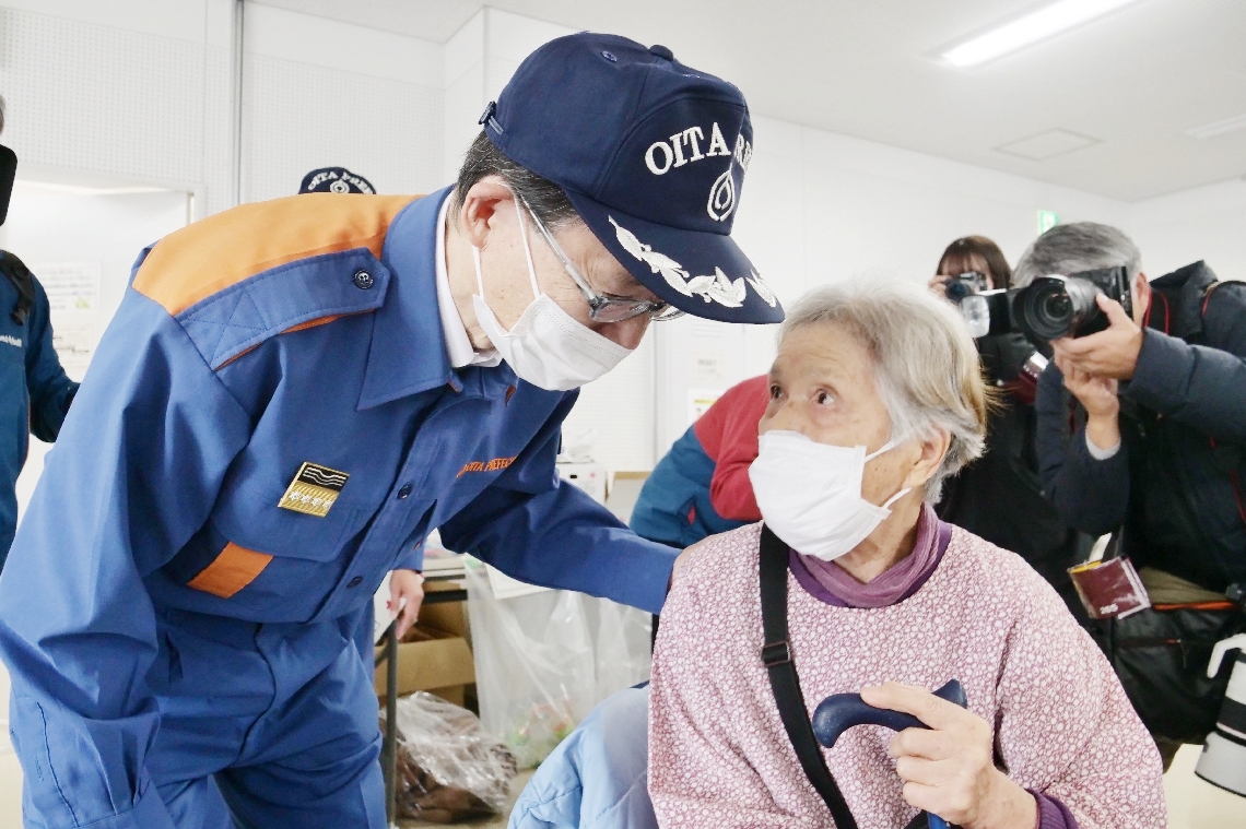 被災者に声をかける佐藤樹一郎知事（左）＝２０日午前１１時２０分、大分市佐賀関