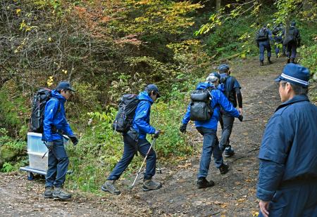 小型航空機墜落事故の現場に向かう運輸安全委員会の航空事故調査官ら＝２０日午前、福岡県八女市
