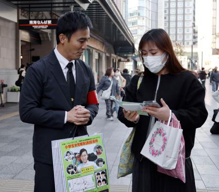 吉川友梨さんの情報提供を呼びかける大阪府警の警察官（左）＝２０日午後、大阪・難波