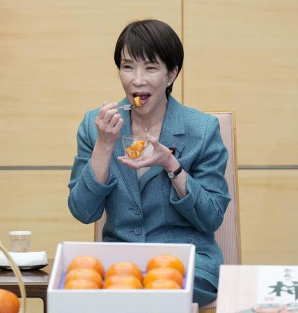 贈呈された奈良県特産の柿を試食する高市首相＝１９日、首相官邸