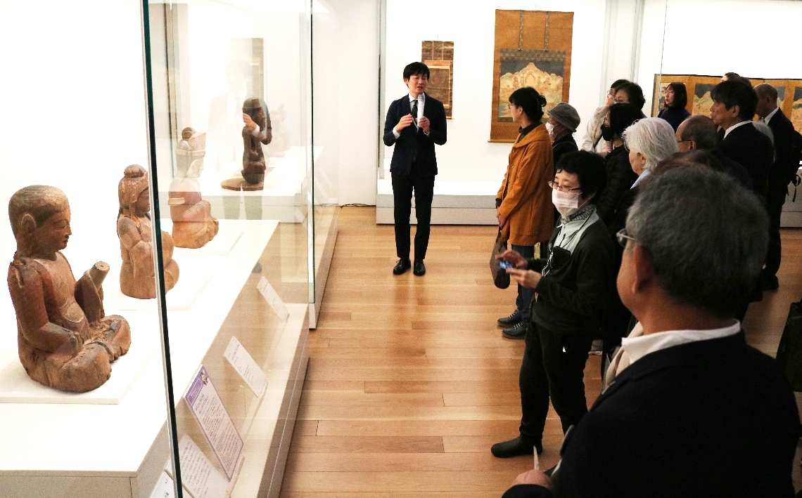 学芸員の解説を聞く来場者