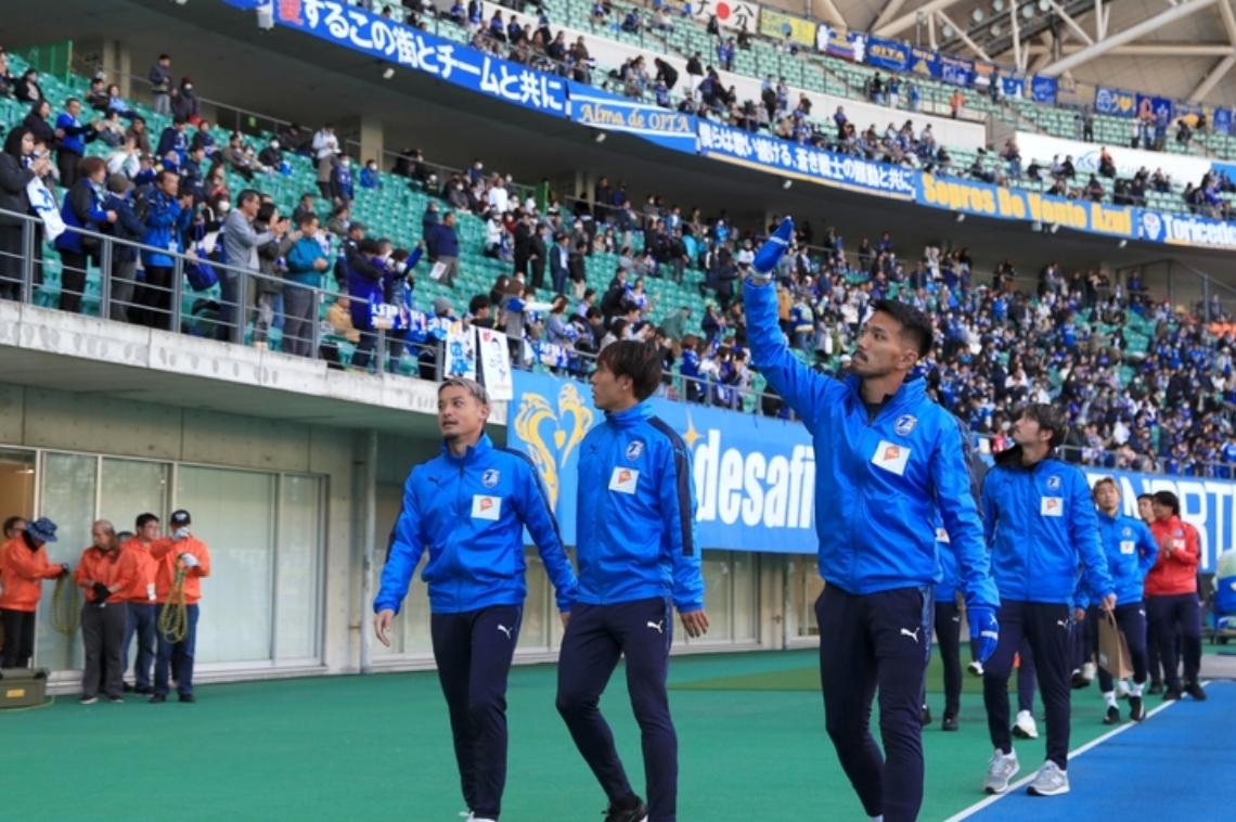 セレモニー後、スタンドのサポーターに手を振る大分の選手たち