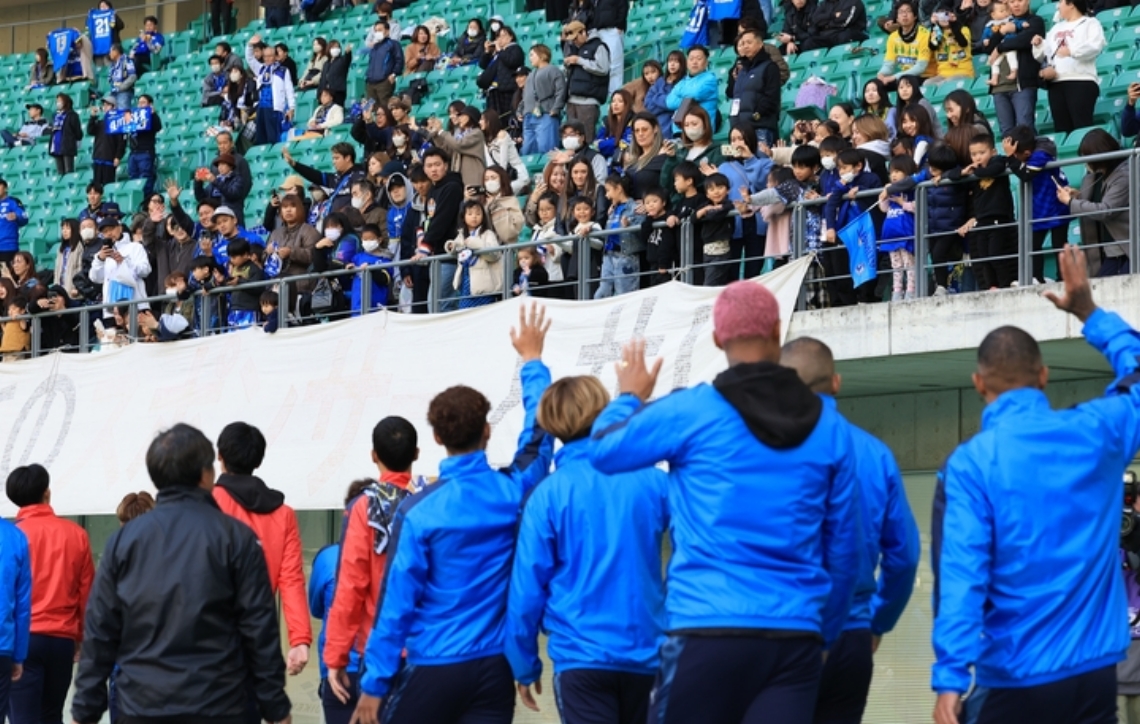 セレモニー後、会場を回る選手たちに手を振るスタンドのサポーター