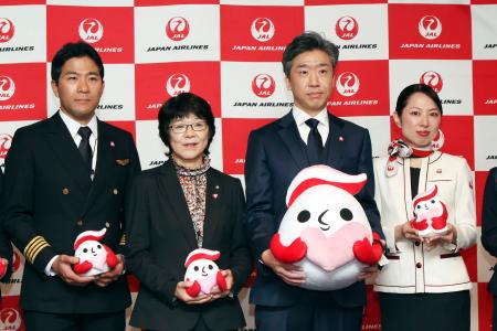 犯罪被害者支援のシンボルマーク「ギュっとちゃん」を紹介する警察庁幹部（右から２人目）と日航の職員ら＝２５日午前、羽田空港