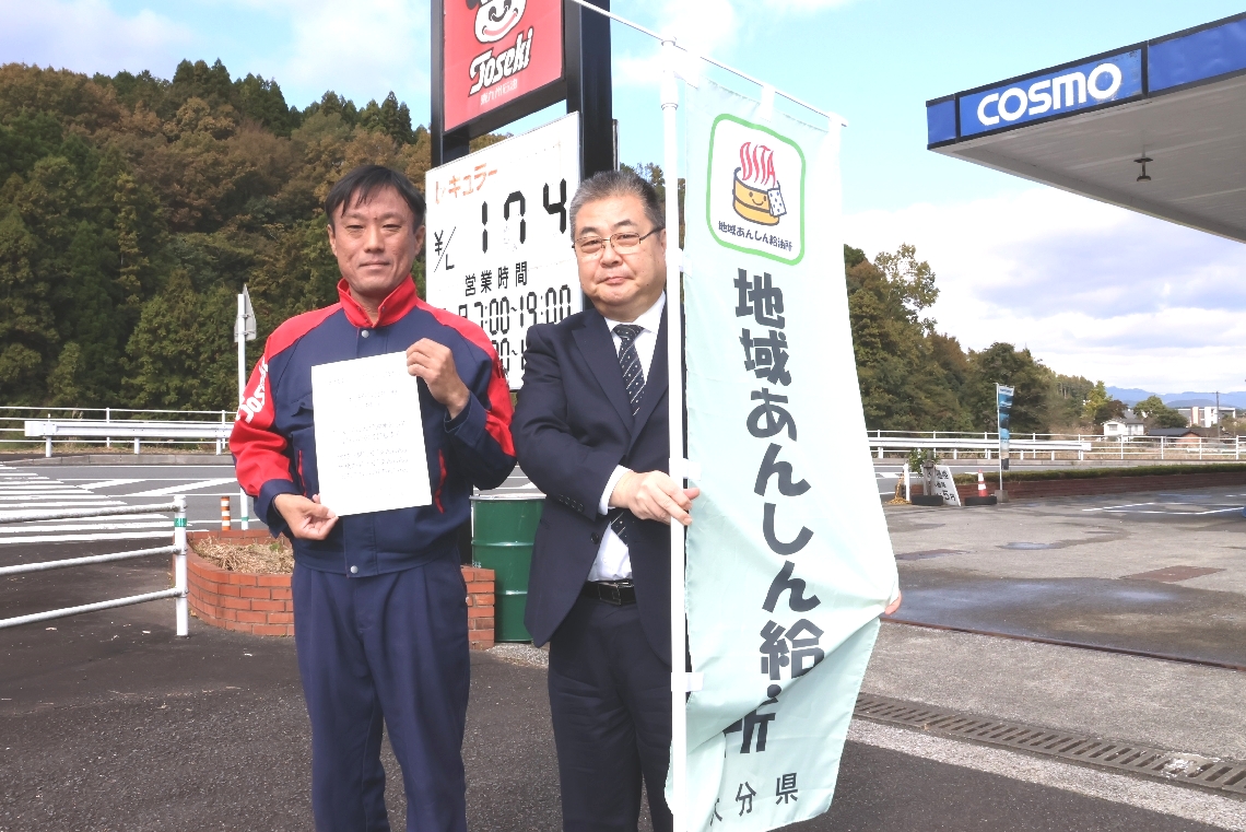 「地域あんしん給油所」の登録証などを手にする佐々木大亮社長（左）と木内直道県民生活・男女共同参画課長＝豊後大野市三重町内山