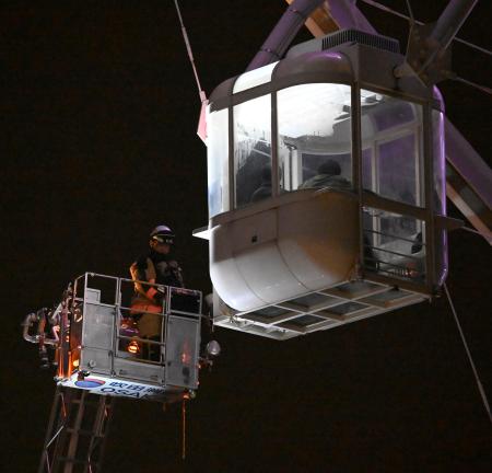 観覧車に閉じ込められた乗客を救助する消防隊員＝２６日午前２時３４分、大阪府吹田市