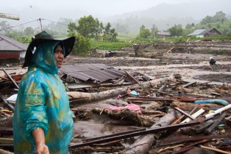 ２７日、インドネシアの西スマトラ州で洪水被害を確認する女性（ＡＰ＝共同）