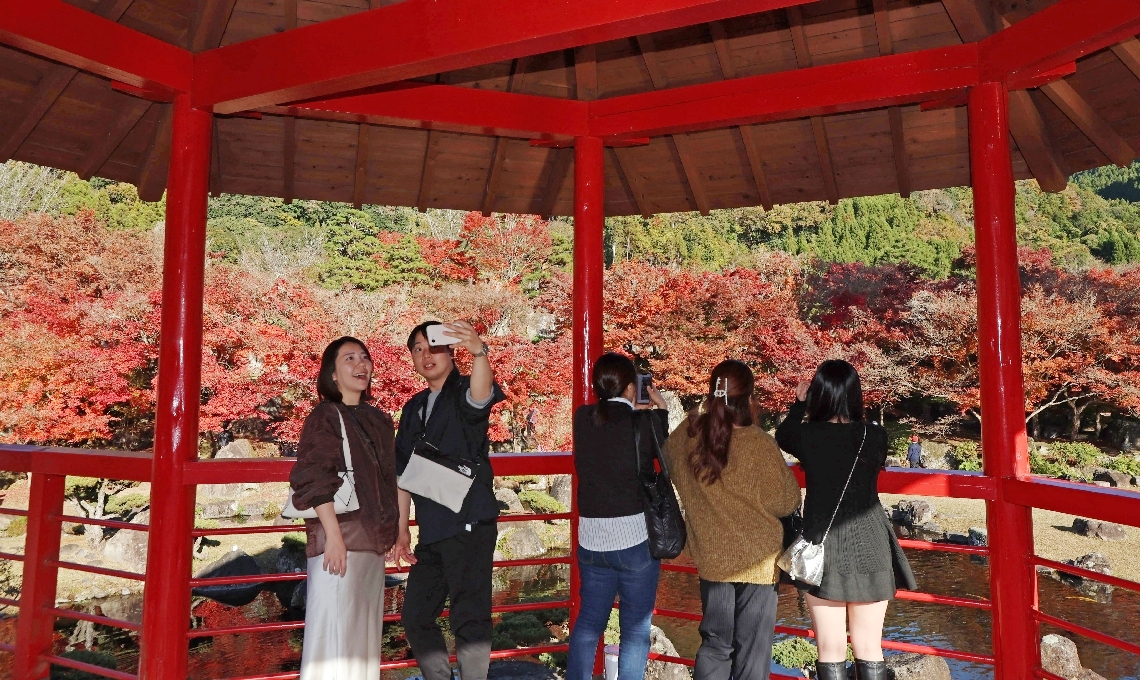 美しい景色を写真に収める観光客＝２３日、中津市耶馬渓町の渓石園