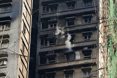消火活動が続く火災現場の高層住宅＝２８日、香港北部・新界地区大埔（共同）