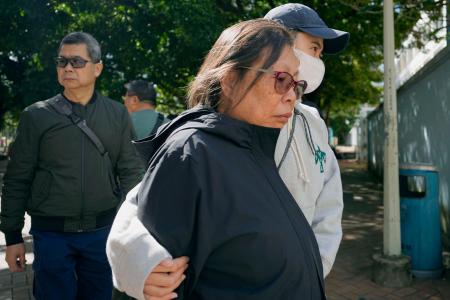 犠牲者の身元確認を行う写真の保管場所から出てきた女性＝２８日、香港北部・新界地区大埔（共同）