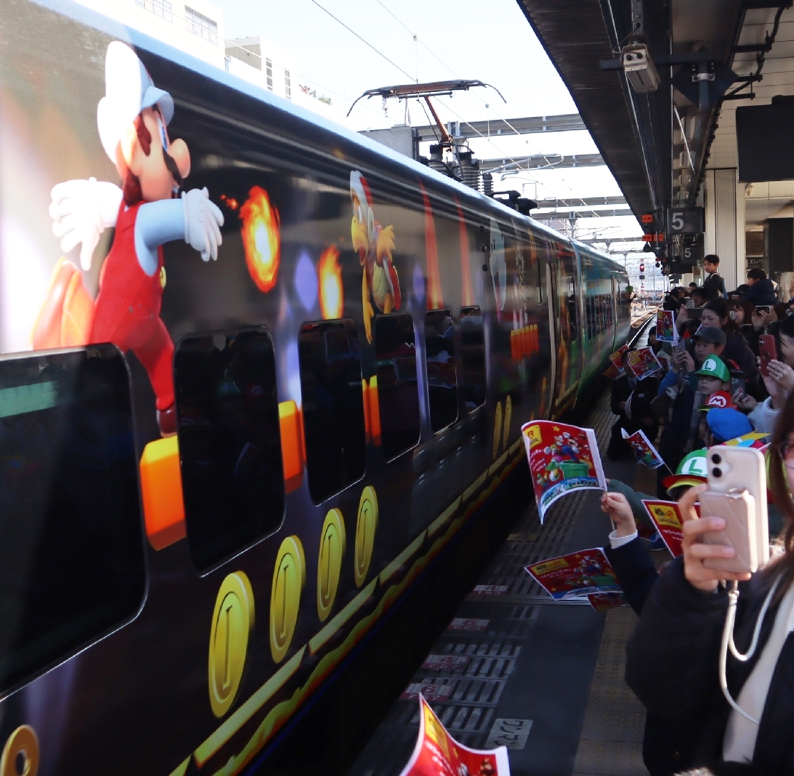 人気キャラクターをあしらったソニックを家族連れらが手旗を振って歓迎