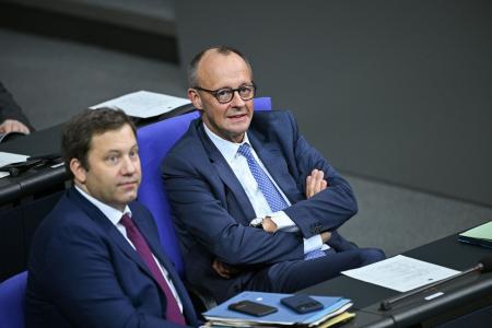 ベルリンのドイツ連邦議会での予算案審議を見守るメルツ首相（右）＝２８日（ロイター＝共同）