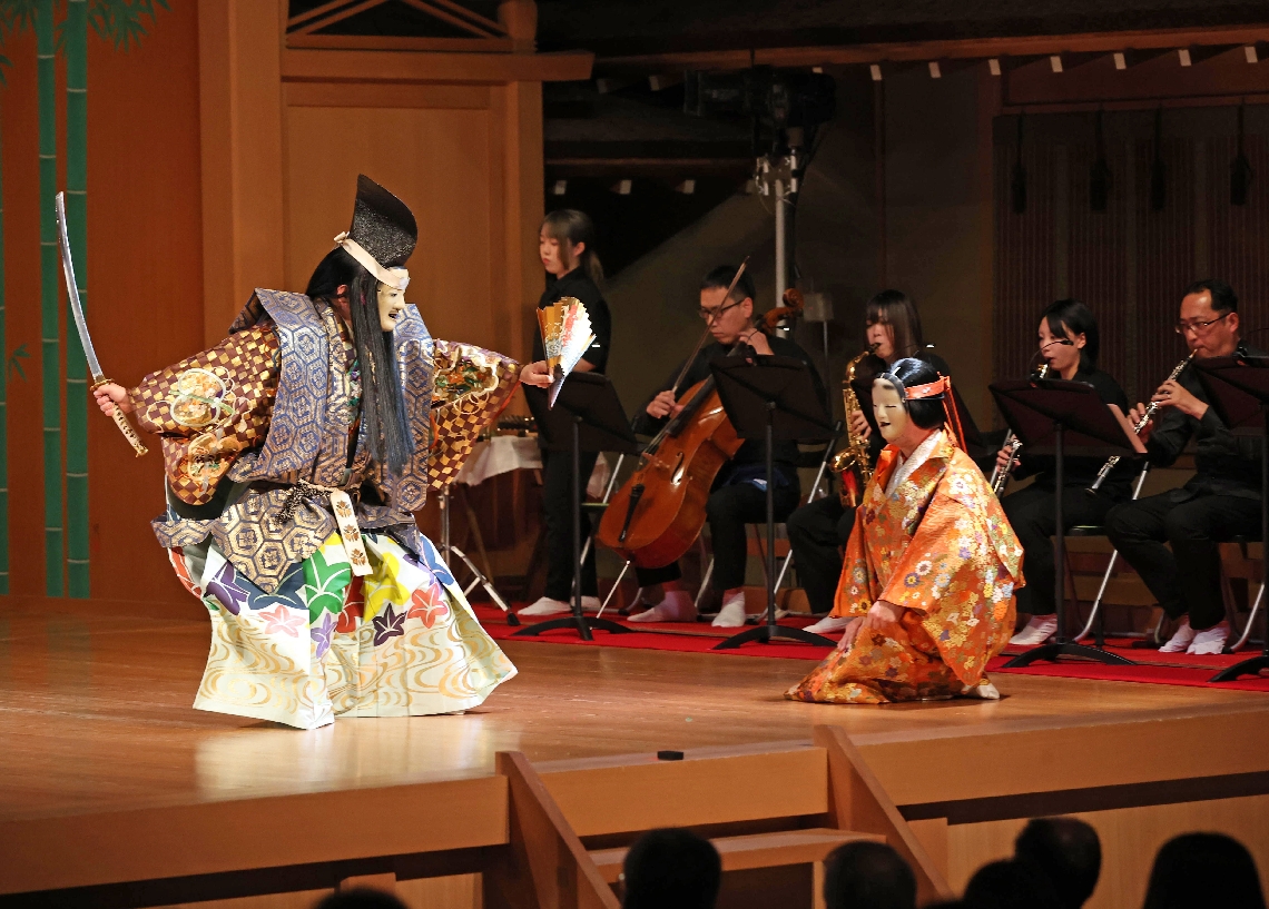 コラボ能「清経」。華麗な舞に合わせ、県立芸術文化短期大の学生ら（奥）が洋楽器を奏でた＝３０日、大分市牧緑町の平和市民公園能楽堂