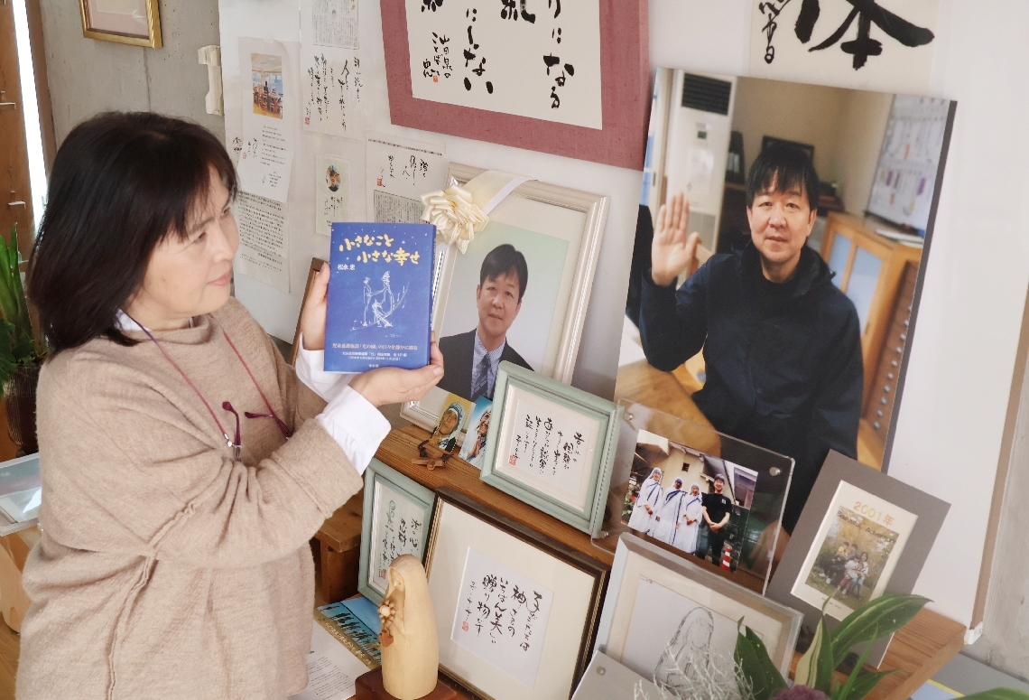 松永忠さんの写真に著書の完成を報告する妻の久美さん＝別府市