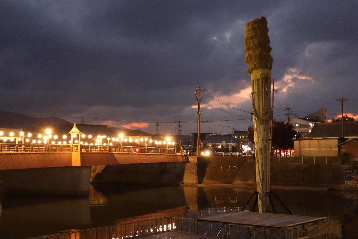 桂川に立てられた大たいまつ。御玉橋（左）から火矢を放って点火する