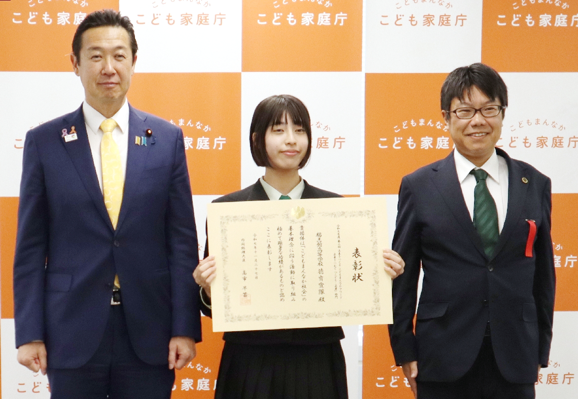 黄川田仁志内閣府特命担当相（左）から表彰状を受け取った楊志館高徳育宣隊の小野栞莉さん（中央）＝東京都千代田区のこども家庭庁