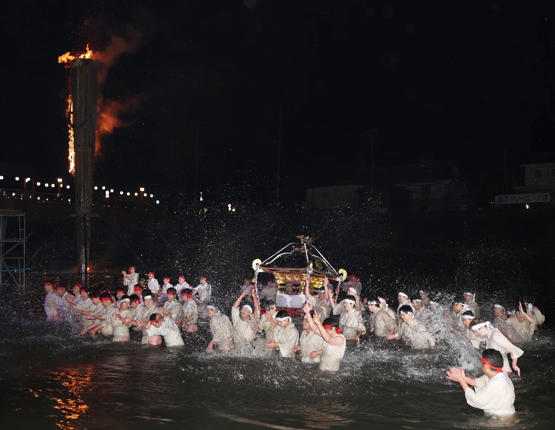 水しぶきとともに気勢を上げる川組の男衆と、燃え上がる大たいまつ