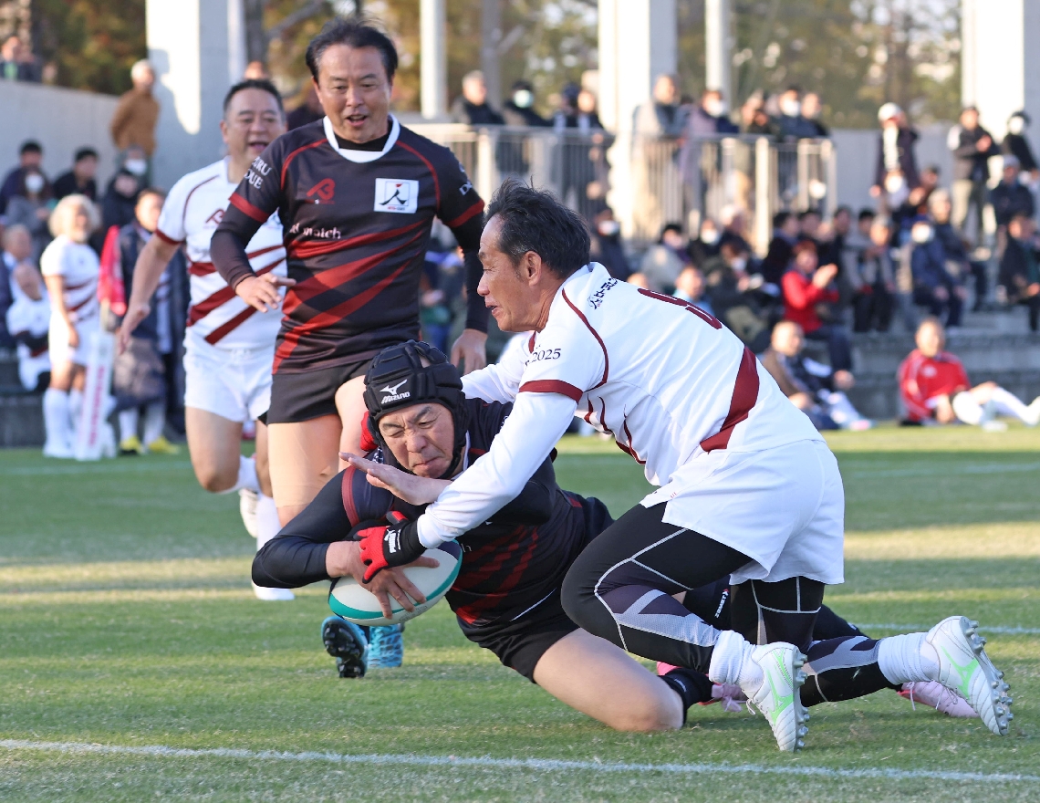 前半、タックルを受けながらトライを決める大分舞鶴ＯＢ