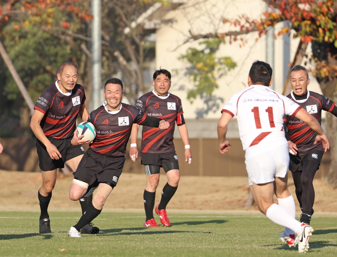 前半、笑顔でプレーする大分舞鶴ＯＢら