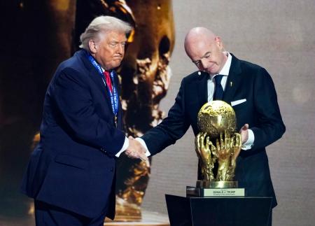 サッカーＷ杯北中米３カ国大会の組み合わせ抽選会でＦＩＦＡ創設の「平和賞」に選ばれ、インファンティノ会長（右）と握手を交わすトランプ米大統領＝５日、米ワシントン（共同）