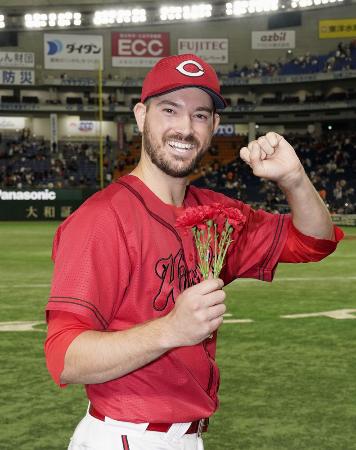 カーネーションを手にガッツポーズする広島・アンダーソン＝２０２３年、東京ドーム