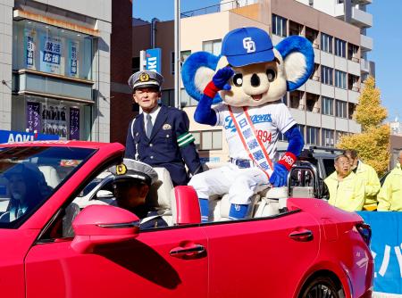 オープンカーでパレードし、集まったファンらに敬礼するドアラ＝６日午前、名古屋市