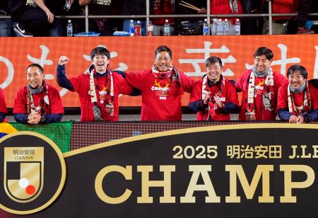 ９年ぶり９度目の優勝を果たし、笑顔で写真に納まる鹿島の柳沢コーチ（左から３人目）、鬼木監督（同４人目）ら＝メルスタ