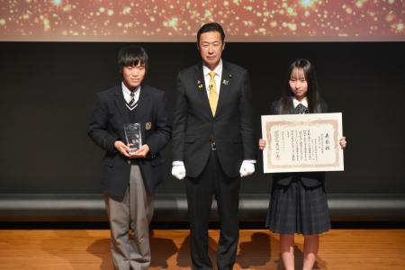 地方創生担当大臣賞に選ばれた、愛知県立猿投農林高校チームのメンバー。中央は黄川田地方創生相＝６日午後、東京都千代田区