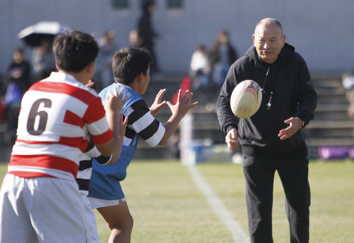 キャッチやパスのこつを教えるジョーンズ監督（右端）＝豊後企画フィールド