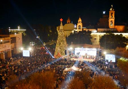 ６日、ヨルダン川西岸ベツレヘムの聖誕教会前の広場で点灯されたクリスマスツリー（共同）