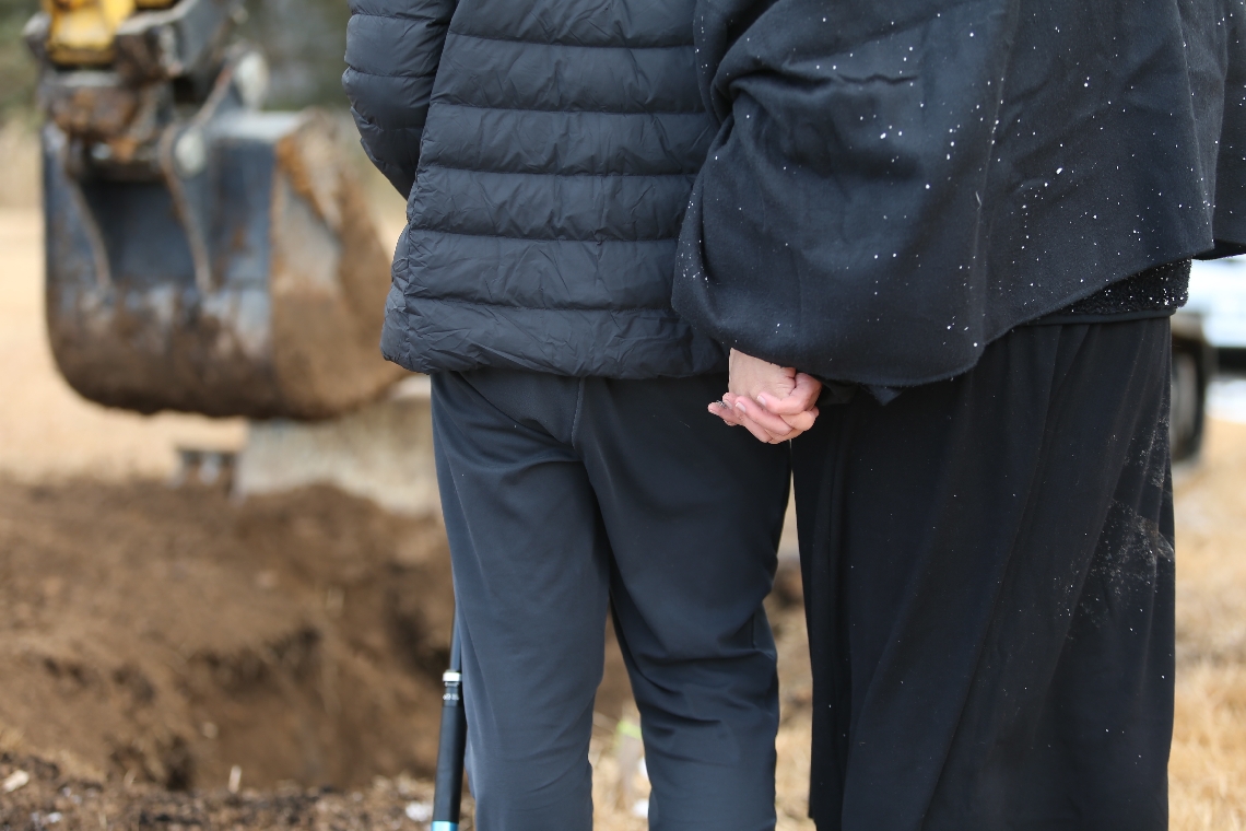 ディヤーちゃんの土葬を見守る父親のユハン・クエクさん（左）と母親の呉超群さん。指を絡めて寄り添い合った