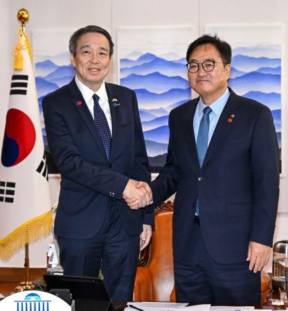 水嶋光一駐韓国大使（左）と握手する韓国の禹元植国会議長＝８日、韓国国会（共同）