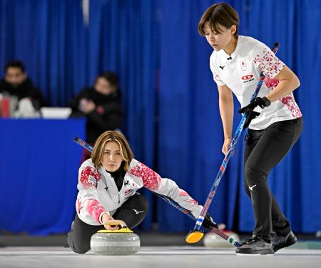 女子１次Ｌ　トルコ戦の第５エンドでショットを放つ吉村。右は小野寺＝ケロウナ（共同）